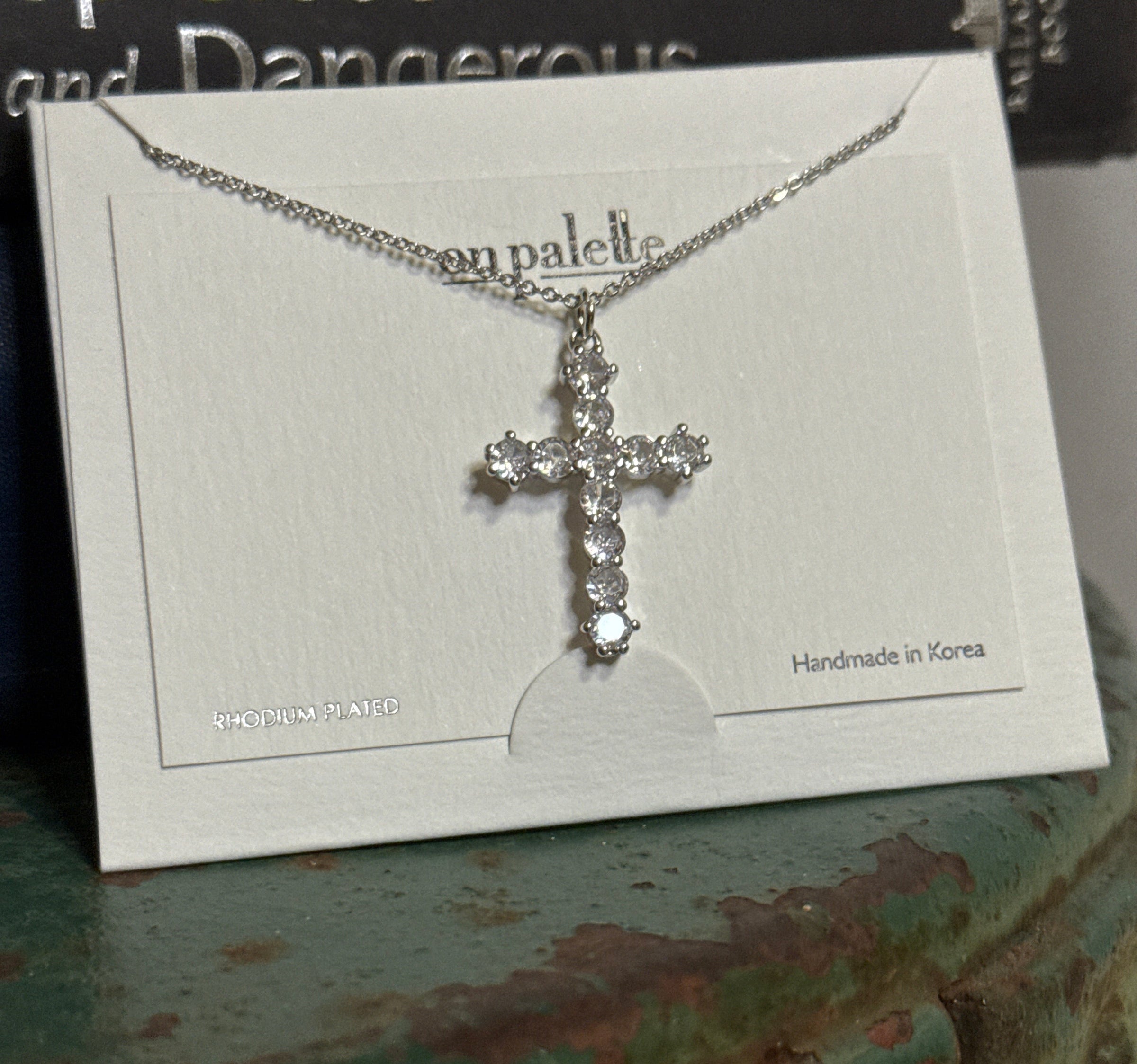 Silver cross necklace on a card 