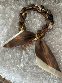 Bracelet with braided design and brown ribbon on a textured surface