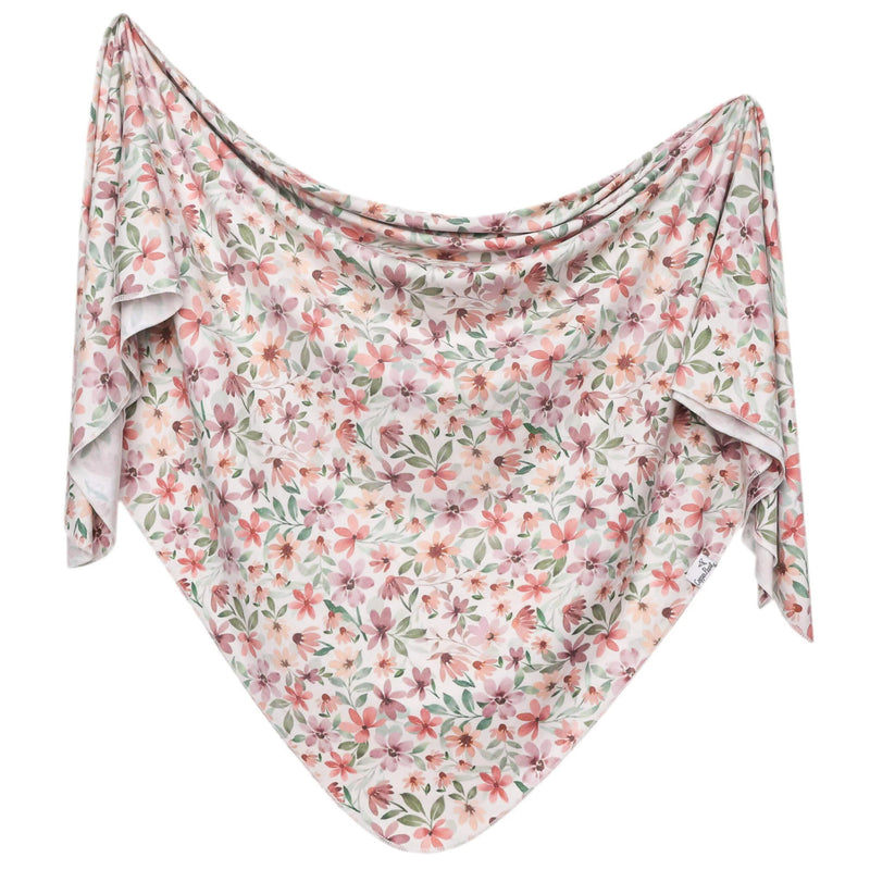Floral patterned fabric swaddle draped over a white background