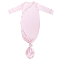 A light pink knotted gown for babies, featuring a V-neckline, side snaps and a knotted hem.